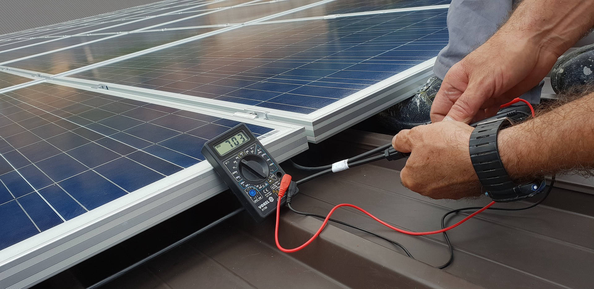 Home battery storage unit mounted on a wall next to a solar inverter